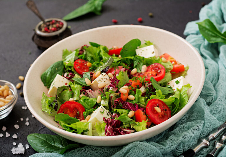 Dietary salad with tomatoes, feta, lettuce, spinach and pine nuts